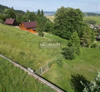 Freizeitgrundstücke in Vyšné Ružbachy mit Holzhütten, umgeben von Grün und Hügeln.