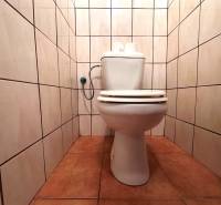 Toilette in einer 3-Zimmer-Wohnung mit Fliesen an den Wänden und auf dem Boden.