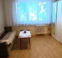 Ein Zimmer in einer 3-Zimmer-Wohnung mit einem Sofa, einem Tisch und einem großen Schrank.