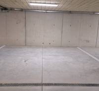 Parkplatz in einer Tiefgarage mit Betonwänden und -boden.