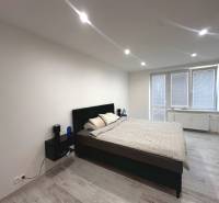 Schlafzimmer in einer 2-Zimmer-Wohnung, mit Bett und Nachttischen, hellem Boden.