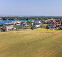 Grundstücke - Wohnen in Dunajská Lužná mit Blick auf den See, Häuser und Felder.