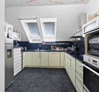 Küche in einem Einfamilienhaus mit Ausstattung, schrägen Dachfenstern und Geräten.