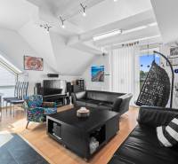 Wohnzimmer in einem Einfamilienhaus mit Ledersofas, Schaukelstuhl und Esstisch.