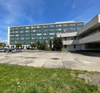 Bürogebäude in der Straße K výstavisku in der Stadt Trenčín mit Parkplatz und Grünflächen.