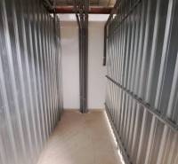 Stauraum in einer 2-Zimmer-Wohnung mit Metallwänden und Rohren.