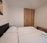 Schlafzimmer in einer 2-Zimmer-Wohnung mit Bett, Holzschrank und Bild an der Wand.
