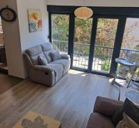 Wohnzimmer einer 3-Zimmer-Wohnung mit Sofa, Balkon und Hochstuhl für Kleinkinder.