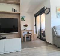Wohnzimmer in einer 3-Zimmer-Wohnung mit Fernseher und bequemen Sessel.