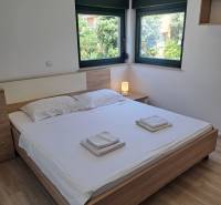 Schlafzimmer in einer 3-Zimmer-Wohnung mit Doppelbett, Fenstern und Nachttisch.