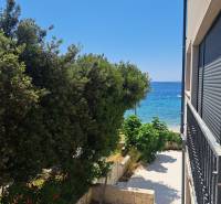 Blick aus einer 3-Zimmer-Wohnung in Mandre auf das Meer, gesäumt von Grün und Fliesen.