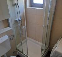 Badezimmer mit Toilette und Duschkabine in einer 3-Zimmer-Wohnung.
