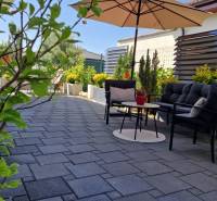 Terrasse eines Einfamilienhauses in Galanta mit Möbeln, Bäumen und Sonnenschirm in der Straße Galanta.