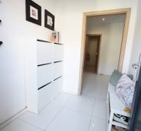 Der Flur in einem Einfamilienhaus mit Sofa, weißen Möbeln und Dekorationen.