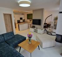 Wohnzimmer in einem Einfamilienhaus mit komfortabler Sitzgelegenheit und moderner Küche.