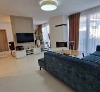Innenraum eines Einfamilienhauses mit Sofa, Fernseher und Esstisch.