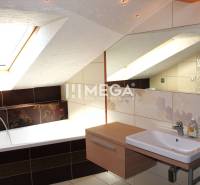 Badezimmer mit Dachfenster, Badewanne und Waschbecken in einer 3-Zimmer-Wohnung.