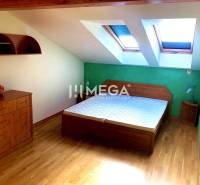 Schlafzimmer mit Holzboden und Doppelbett in einer 3-Zimmer-Wohnung.