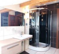 Badezimmer in einer 3-Zimmer-Wohnung mit Duschkabine und großem Spiegel.