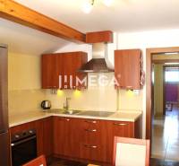 Küche mit Holzschränken und Edelstahlgeräten in einer 3-Zimmer-Wohnung.