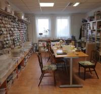 Interieur eines Gebäudes mit Tischen und Regalen voller Materialien für kreative Aktivitäten.