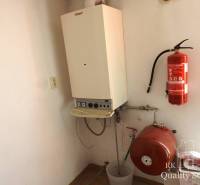 Heizung im Gebäude mit einem Kessel und einem Feuerlöscher an der Wand.