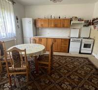 Küche in einem Einfamilienhaus mit Esstisch, Holzschränken und Gasherd.