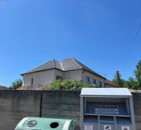 Ein Einfamilienhaus in Sasinkovo in der Straße Sasinkovo hinter einem Betonzaun mit blauem Himmel.