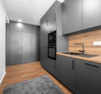 Küche mit schwarzen Schränken und einer Arbeitsplatte aus Holz in einer 3-Zimmer-Wohnung.