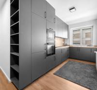 Küche in einer 3-Zimmer-Wohnung mit grauen Schränken und Holzboden.