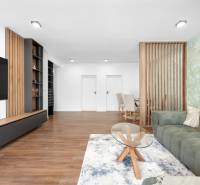 Wohnzimmer mit einem Teppich und einem grünen Sofa in einer 3-Zimmer-Wohnung.