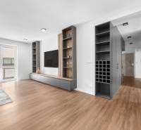 Helles Wohnzimmer in einer 3-Zimmer-Wohnung mit Holzboden und eingebauten Regalen.