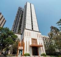 Wohnungsbau in Pattaya, ein hohes Gebäude mit moderner Architektur und Grünflächen in der Umgebung.