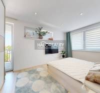 Helles Schlafzimmer mit großem Bett und Balkontüren in einer 3-Zimmer-Wohnung.