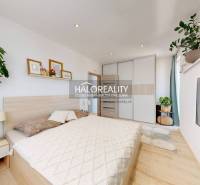Schlafzimmer in einer 3-Zimmer-Wohnung mit Bett, Schrank, Bildern und grünen Pflanzen.