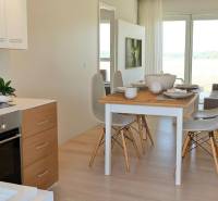Esstisch mit Stühlen und Küche in einer 3-Zimmer-Wohnung mit heller Dekoration.