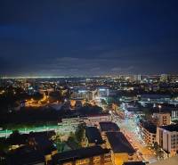 Nachtpanorama von Pattaya, Blick aus einer Einzimmerwohnung auf die beleuchtete Stadt.