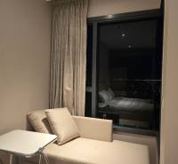 Ein Sofa und ein Tisch in einer Einzimmerwohnung mit nächtlichem Ausblick.