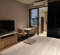 1-Zimmer-Wohnung mit TV, Bett, Tisch, Küchenzeile und Klimaanlage.