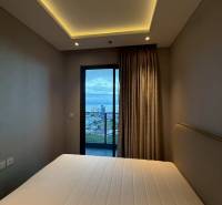 Schlafzimmer mit eingebauter Beleuchtung und Blick auf den Balkon, 3-Zimmer-Wohnung.
