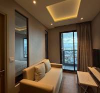 Wohnzimmer in einer 3-Zimmer-Wohnung mit Sofa, Fernseher und Blick auf die Stadt.
