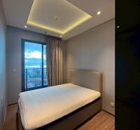 Schlafzimmer in einer 3-Zimmer-Wohnung mit Bett, Einbauschrank und Vorhängen am Fenster.