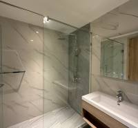 Badezimmer mit Duschkabine und Waschbecken in einer 3-Zimmer-Wohnung mit elegantem Design.