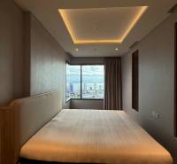 Schlafzimmer in einer 3-Zimmer-Wohnung mit großem Fenster und Blick auf die Stadt.