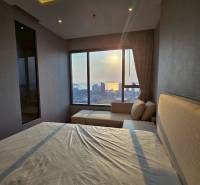 Ein Schlafzimmer in einer 3-Zimmer-Wohnung mit Blick auf den Sonnenuntergang über der Stadt.