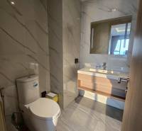Badezimmer mit Marmorfliesen und Toilette in einer 3-Zimmer-Wohnung.
