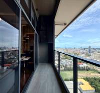 Blick aus einer 4-Zimmer-Wohnung in Pattaya. Balkon mit verglastem Geländer und Stadtpanorama.