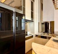 Küche in einer 4-Zimmer-Wohnung, mit Marmorarbeitsplatte und verspiegeltem Kühlschrank.