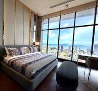 Schlafzimmer in einer 4-Zimmer-Wohnung mit großem Fenster bietet Blick auf die Stadt und die Küste.