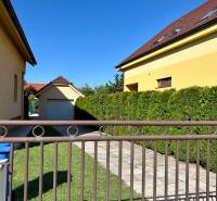 Ein Haus mit Garage in der Bradlanská-Straße in Trnava, umgeben von Rasen und einem Zaun.